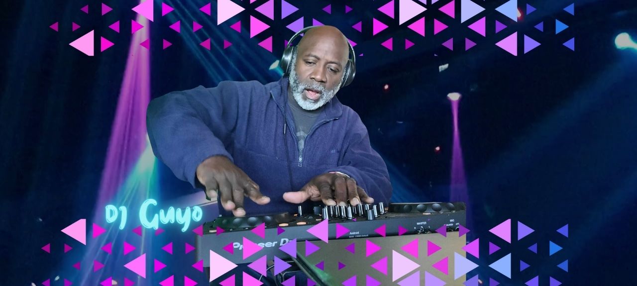 DJ mixing music on professional controller with colorful stage lighting