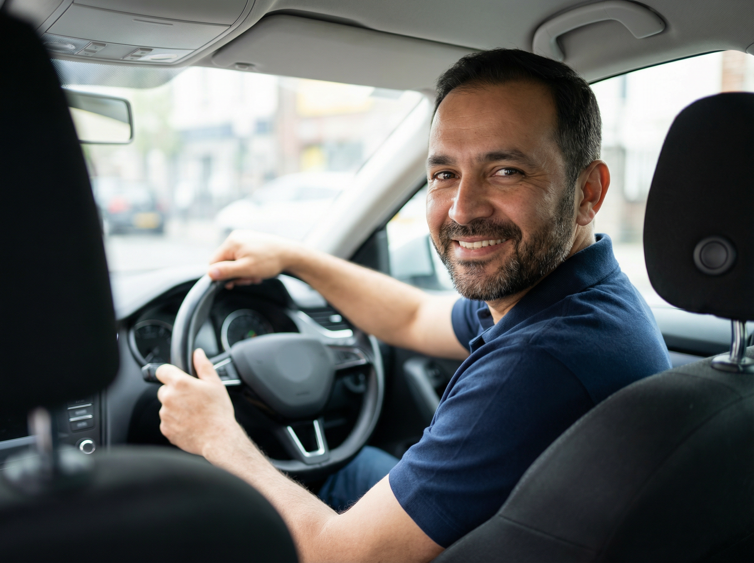Friendly CRB-checked Licensed Taxi driver smiling from the driver seat