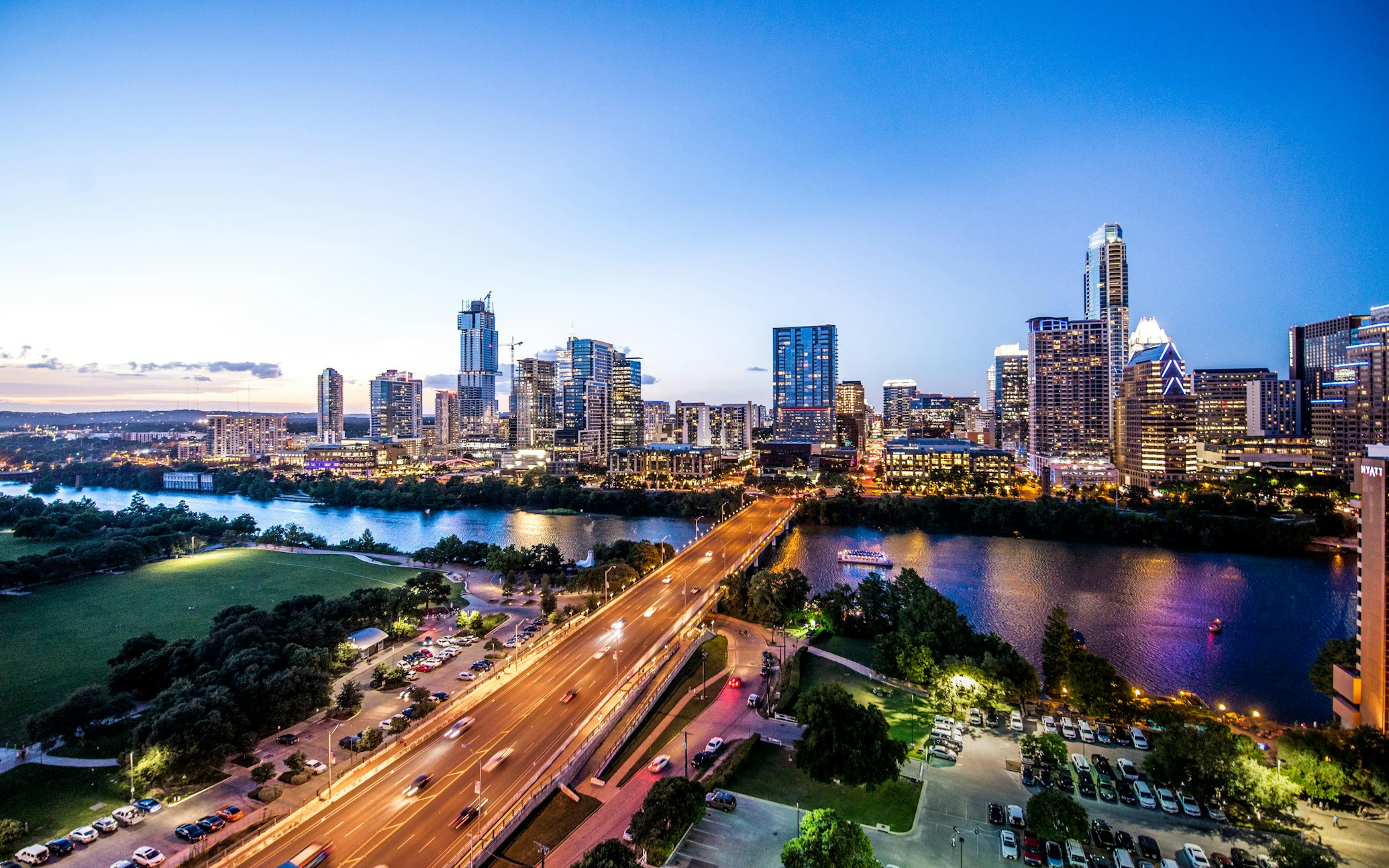 Austin city skyline at dusk with river and glowing lights